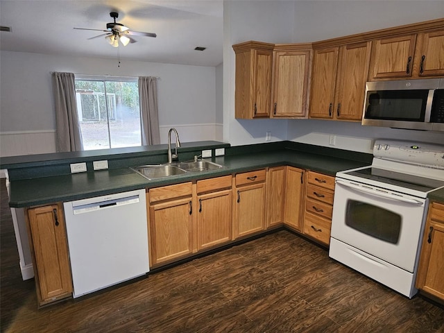 kitchen featuring sink, white appliances, ceiling fan, dark hardwood / wood-style floors, and kitchen peninsula