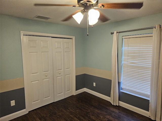 unfurnished bedroom featuring dark hardwood / wood-style flooring, a closet, and ceiling fan