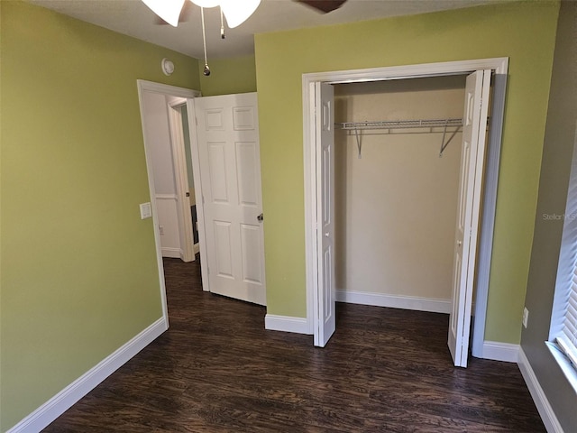 unfurnished bedroom featuring dark wood-type flooring, a closet, and ceiling fan