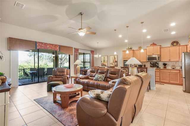 tiled living room featuring vaulted ceiling and ceiling fan with notable chandelier