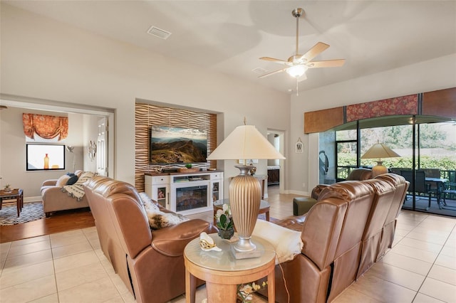 tiled living room featuring ceiling fan and a fireplace