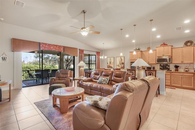 living room featuring ceiling fan with notable chandelier, vaulted ceiling, and light tile patterned flooring