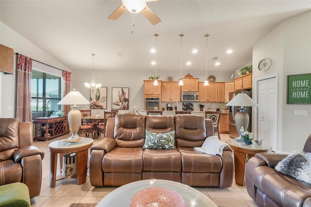 tiled living room featuring lofted ceiling and ceiling fan with notable chandelier