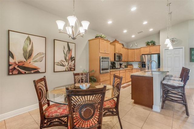 dining area featuring an inviting chandelier, lofted ceiling, sink, and light tile patterned floors