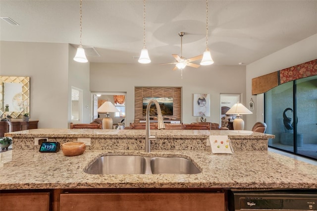 kitchen featuring pendant lighting, sink, ceiling fan, black dishwasher, and light stone counters