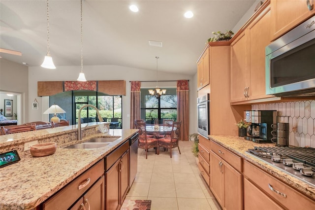 kitchen with vaulted ceiling, decorative light fixtures, sink, backsplash, and stainless steel appliances