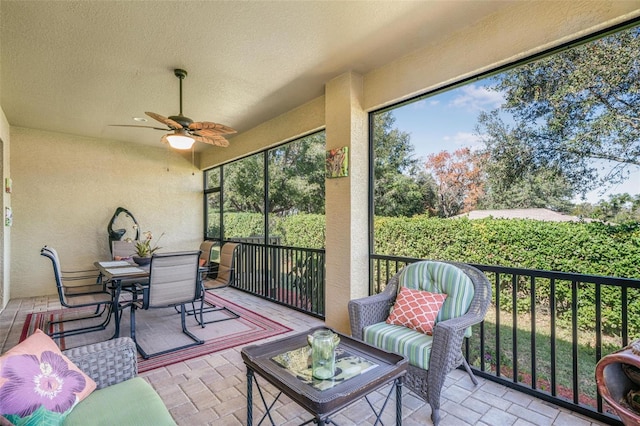 sunroom / solarium featuring ceiling fan