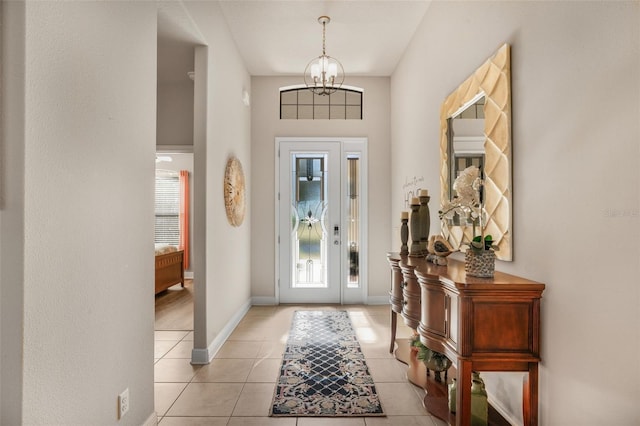 tiled entryway featuring a notable chandelier