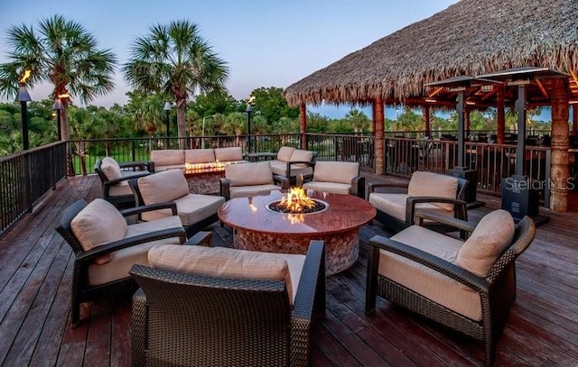 wooden deck with a gazebo and an outdoor living space with a fire pit