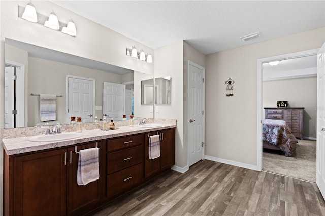 bathroom featuring vanity, wood-type flooring, and a textured ceiling