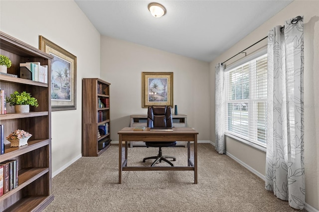 carpeted home office featuring lofted ceiling