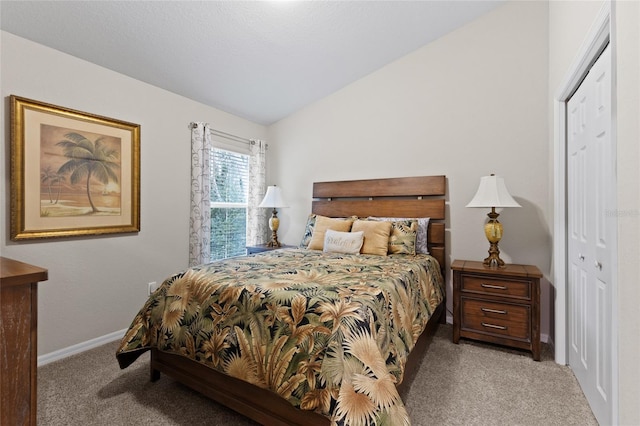 carpeted bedroom featuring vaulted ceiling and a closet