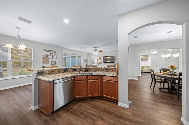 kitchen with light stone countertops, decorative light fixtures, stainless steel dishwasher, and sink