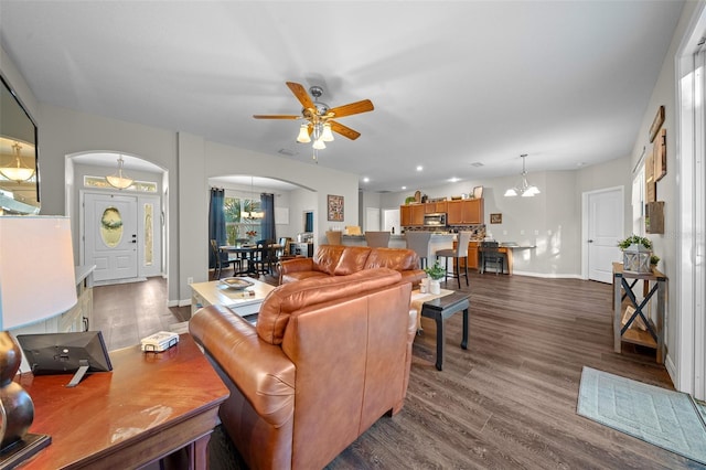 living room with hardwood / wood-style flooring and ceiling fan with notable chandelier