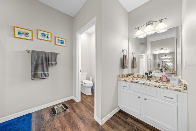 bathroom with vanity, toilet, and hardwood / wood-style floors