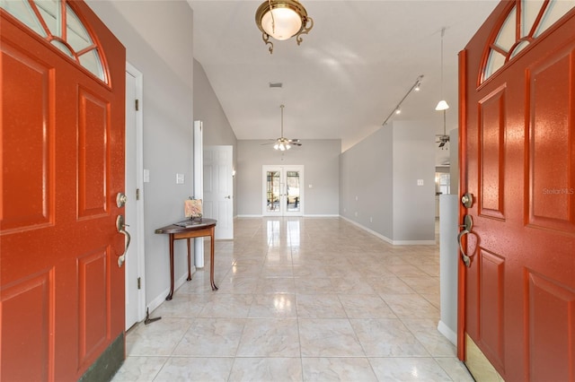 foyer featuring lofted ceiling, ceiling fan, track lighting, light tile patterned flooring, and french doors