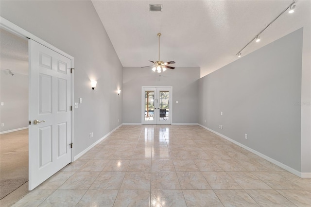 empty room featuring light tile patterned flooring, rail lighting, ceiling fan, and french doors