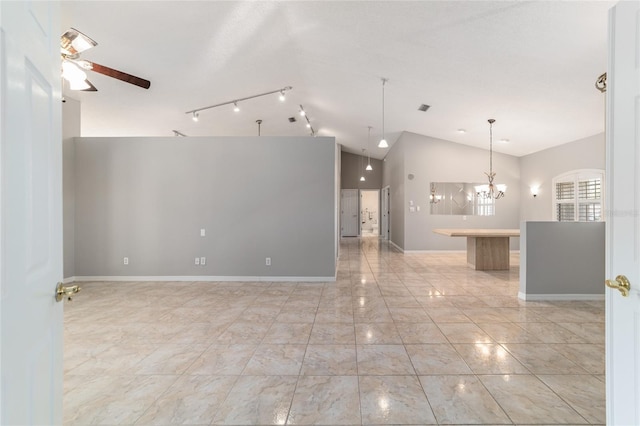 spare room with ceiling fan with notable chandelier and high vaulted ceiling