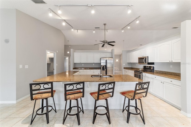 kitchen featuring white cabinetry, stainless steel appliances, and a large island with sink