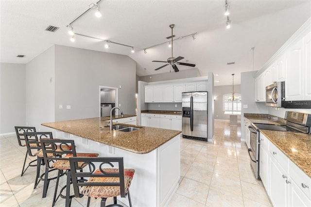 kitchen with appliances with stainless steel finishes, pendant lighting, white cabinetry, sink, and a large island with sink