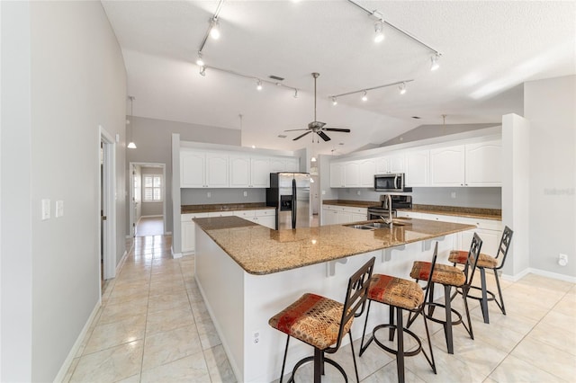 kitchen with vaulted ceiling, sink, white cabinets, a large island, and stainless steel appliances