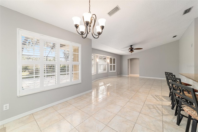 unfurnished dining area featuring light tile patterned floors, ceiling fan with notable chandelier, and a textured ceiling