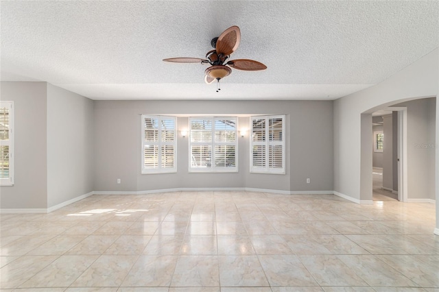 spare room featuring light tile patterned floors, a textured ceiling, and ceiling fan