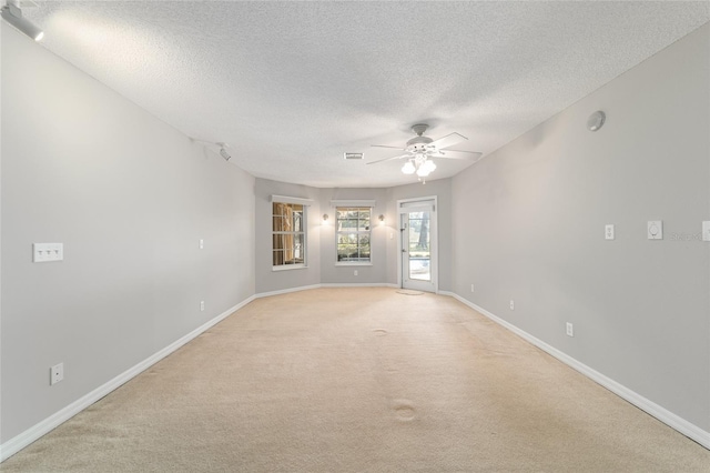 carpeted empty room featuring a textured ceiling and ceiling fan