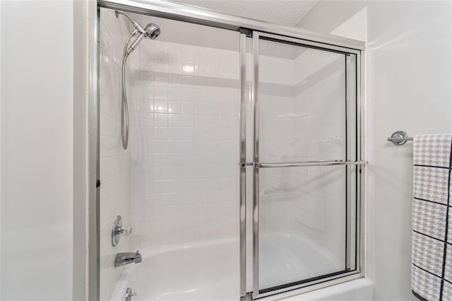 bathroom with enclosed tub / shower combo and a textured ceiling