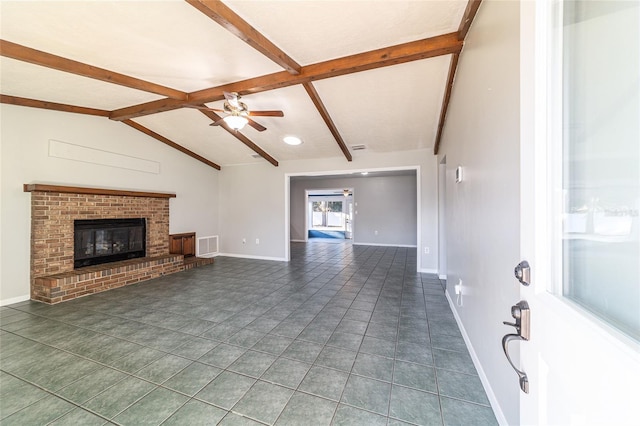 unfurnished living room featuring visible vents, baseboards, vaulted ceiling with beams, a brick fireplace, and dark tile patterned floors