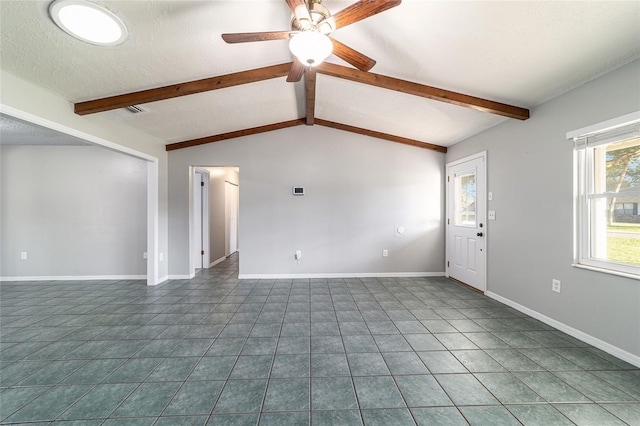 unfurnished living room with a textured ceiling, ceiling fan, lofted ceiling with beams, dark tile patterned flooring, and baseboards