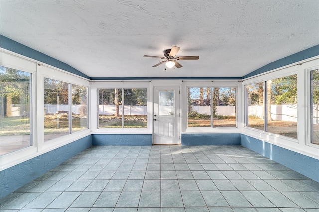 unfurnished sunroom featuring lofted ceiling, ceiling fan, and a healthy amount of sunlight