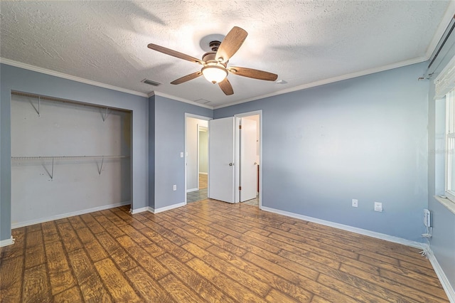 unfurnished bedroom with crown molding, a closet, visible vents, a textured ceiling, and wood finished floors