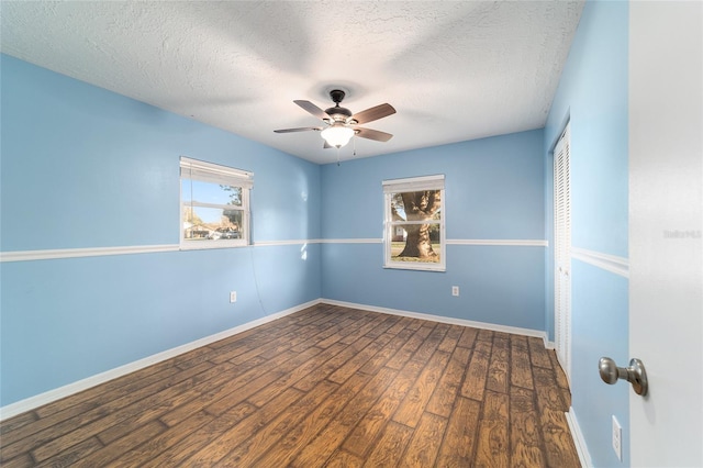 empty room featuring ceiling fan, a textured ceiling, baseboards, and wood finished floors