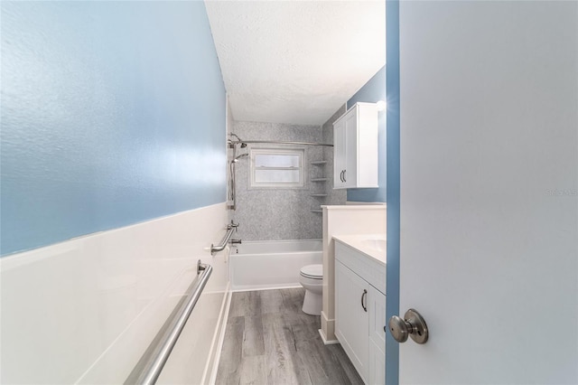 full bath with a textured ceiling, toilet, wood finished floors, vanity, and shower / bathing tub combination