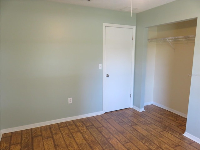 unfurnished bedroom featuring a closet, baseboards, and wood finished floors