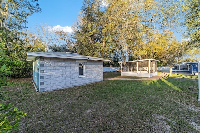 view of yard featuring an outbuilding and a sunroom