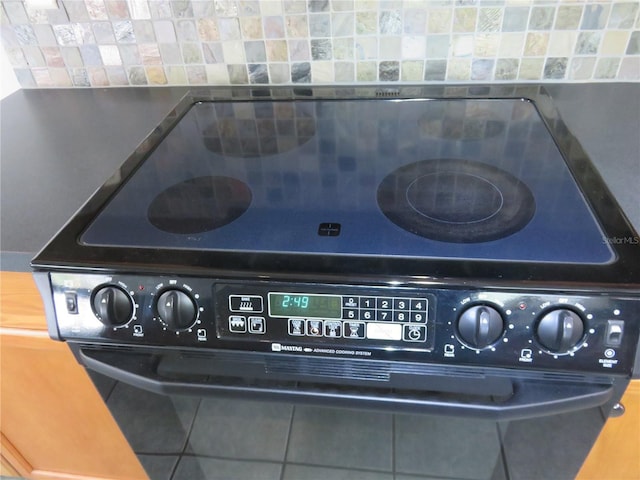 interior details featuring black range with electric cooktop and decorative backsplash