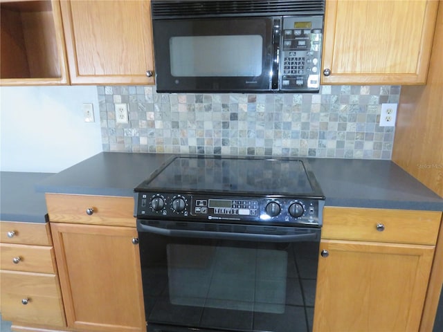 kitchen with tasteful backsplash, dark countertops, and black appliances