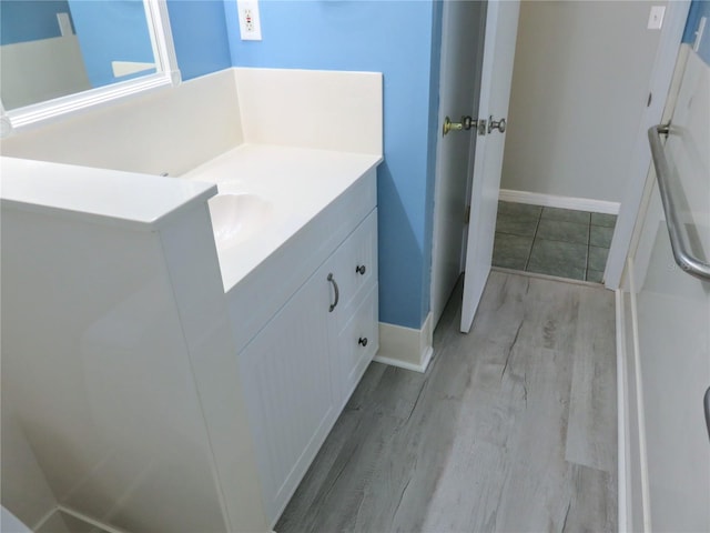 bathroom featuring vanity, baseboards, and wood finished floors