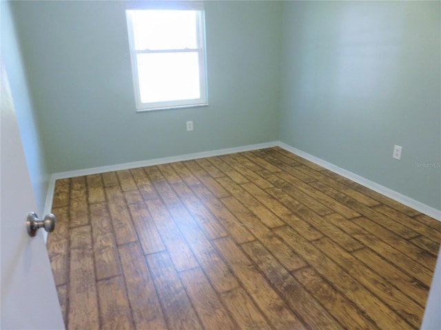 empty room featuring baseboards and hardwood / wood-style floors