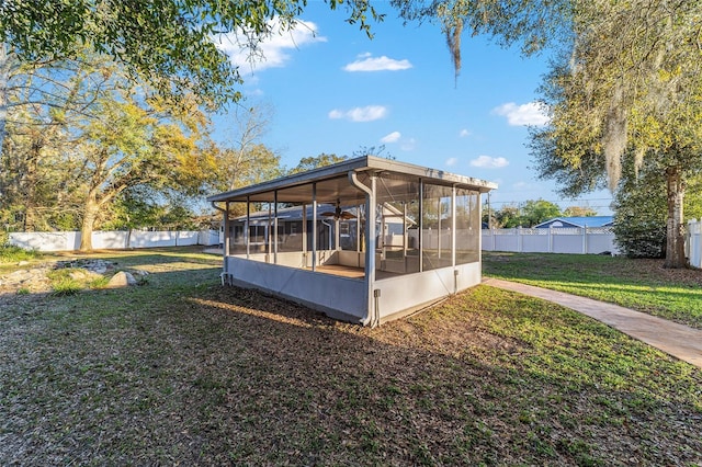 view of outbuilding featuring a fenced backyard and a sunroom