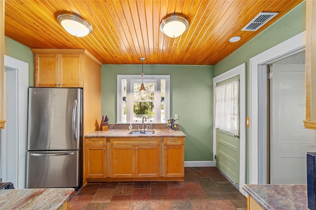 kitchen with pendant lighting, stainless steel fridge, sink, and wooden ceiling