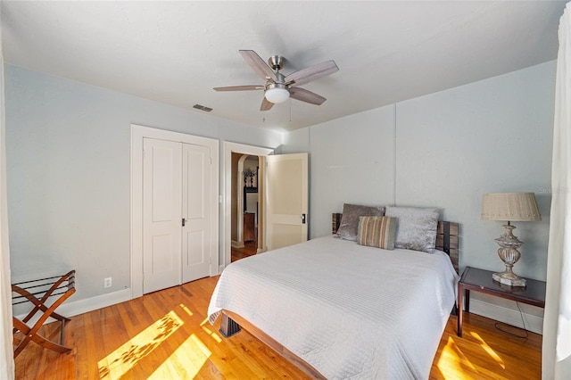 bedroom featuring ceiling fan, a closet, and light hardwood / wood-style flooring