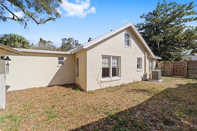 view of property exterior featuring cooling unit and a lawn