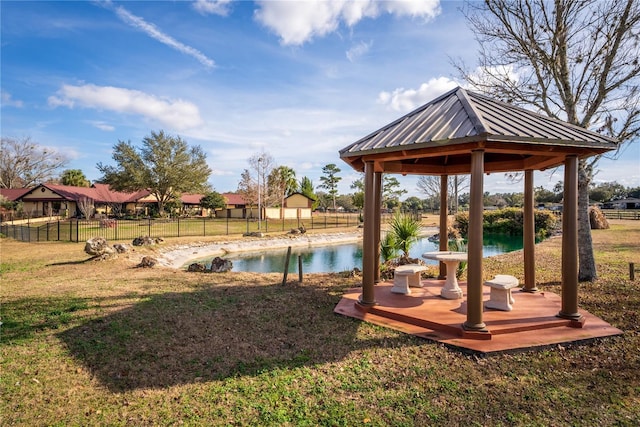 view of yard featuring a gazebo, a water view, and fence