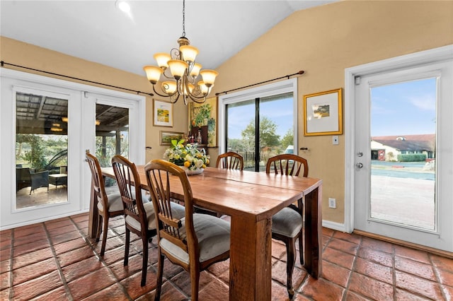 dining room with a chandelier, vaulted ceiling, and french doors