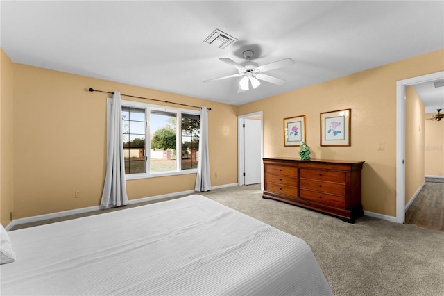 bedroom with baseboards, visible vents, and light colored carpet