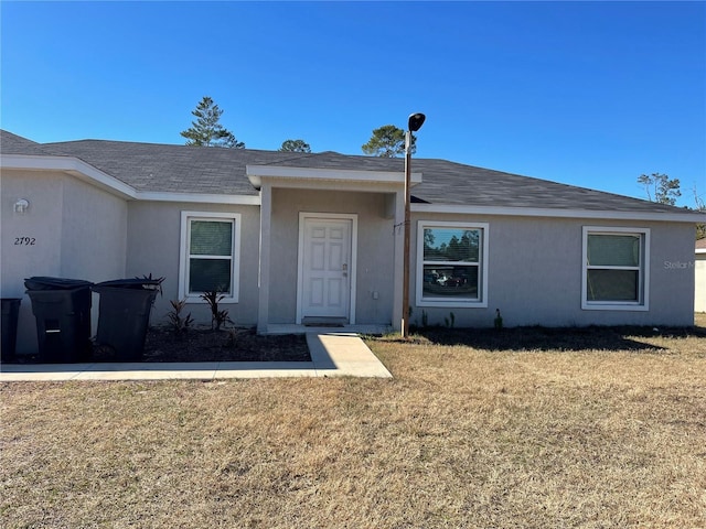 single story home featuring a front lawn