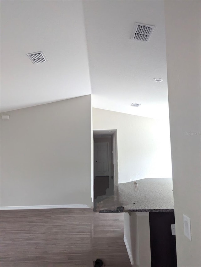 hall with vaulted ceiling and dark hardwood / wood-style floors